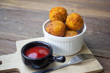 Fried potato cheese balls with tomato ketchup.