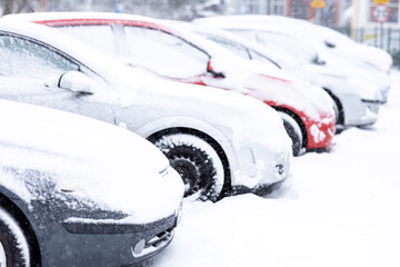 Zimowy krajobraz , śnieg i ośnieżone auta na parkingu.