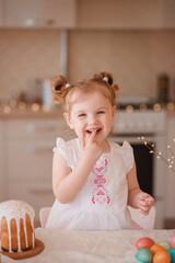 happy cute girl is preparing for easter. smiling girl paints eggs