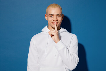 Young happy secret dyed blond man of African American ethnicity wear white hoody say hush be quiet...