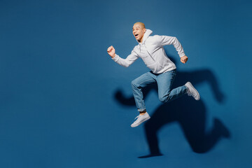 Fototapeta na wymiar Full body side view sporty fun young dyed blond man of African American ethnicity in white hoody jump high run fast hurry up in rush isolated on plain dark royal navy blue background studio portrait