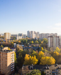 Fototapeta na wymiar The city of Reutov in the Moscow region panoramic top view with modern residential buildings with trees with golden foliage on a sunny autumn day and blue sky above the horizon and space for copy