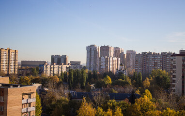 Obraz premium The city of Reutov in the Moscow region panoramic top view with modern residential buildings with trees with golden foliage on a sunny autumn day and blue sky above the horizon and space for copy