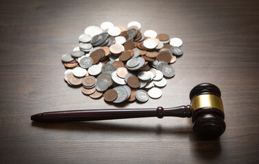 Stack of coins with judge gavel.