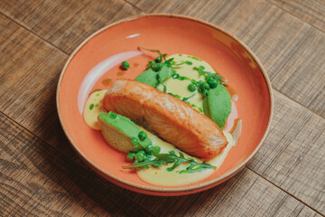 Modern restaurant fresh dish with salmon and vegetables lies on a wooden table