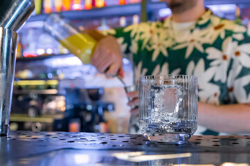 empty glass with ice on a bar counter in bar or pub