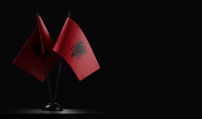 Small national flags of the Albania on a black background