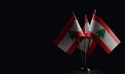 Obraz premium Small national flags of the Lebanon on a black background