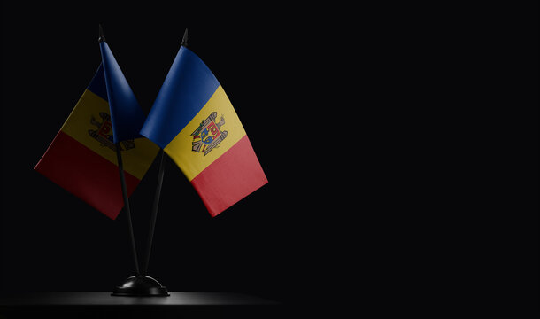 Small national flags of the Moldavia on a black background