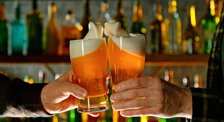 Close-up view of a two glasses of beer in hands.