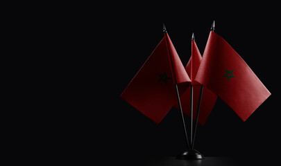 Small national flags of the Morocco on a black background