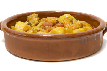 Potato stew with cod, served in a clay bowl. Isolated on white background. Spanish food concept.