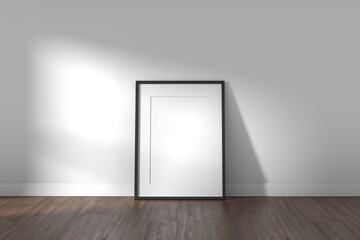 Frame on wooden floor and white wall background with sunlight coming through the window.