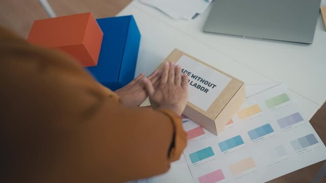 Woman sticking made without child labor label on box, responsible manufacturing
