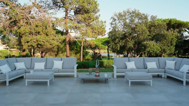 Stylish outdoor dining furniture in a hotel or villa with a view of the green garden.