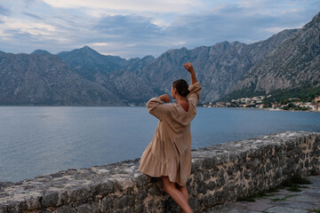 Beautiful woman in a flow dress admiring the landscape, Kotor bay, Montenegro 