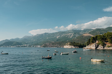 Fototapeta na wymiar Budva coastline with boats and mountains in the backdrop from Sveti Stefan island, Montenegro