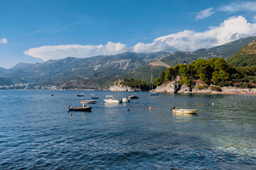 Budva coastline with boats and mountains in the backdrop from Sveti Stefan island, Montenegro