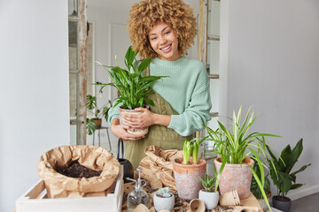 Spring time hobby and passion concept. Positive female botanist embraces potted flower busy...