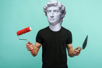Abstract modern collage. The man with the plaster head of David stands with a paint roller and...