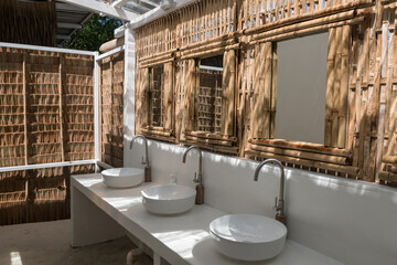 Cafe toilet of washbasin, mirror, wall made by bamboo wood