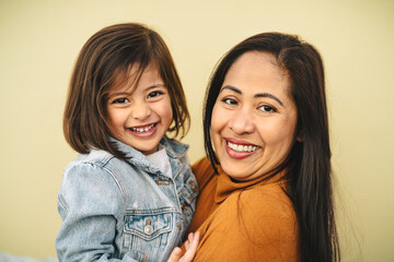 Happy southeast Asian mother with her daughter smiling in front of camera - Lovely family portrait