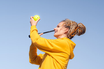 woman playing pickleball game, hitting pickleball yellow ball with paddle, outdoor sport leisure...