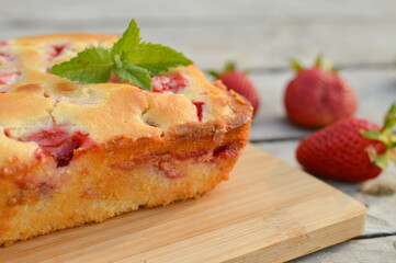 Delicious summer dessert strawberry pie, sweet homemade holiday cake decorated with mint leaves on a light wooden table.