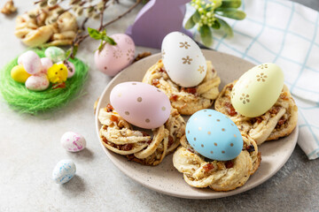 Easter composition. Sweet Italian Easter Bread Rings from puff pastry and dyed eggs on a stone background.