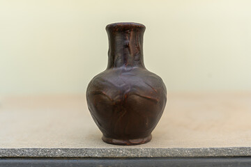 Brown ceramic jug on a gray background. For storage of water, milk.
