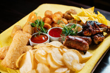 Beer snacks side view. Chips nuggets and chicken.