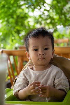 Portrait of Asian boy sit on his chair in the coffee shop