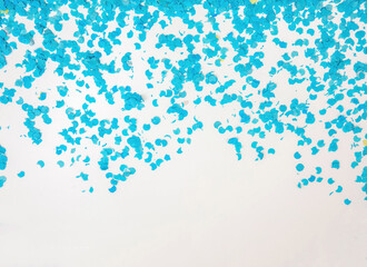 Confetti blue scattered on white background. Carnival party. Ad template, space. Overhead view.