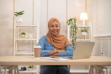 Fototapeta na wymiar Portrait Of Young Black Muslim Woman In Hijab Using Laptop At Home .Work at home concept.