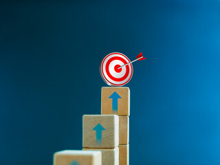 3d target icon on the top of wooden cube blocks, bar graph chart steps with up arrows on blue...