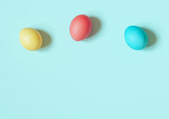 Colorful painted Easter eggs on the blue background. Top view. Copy space
