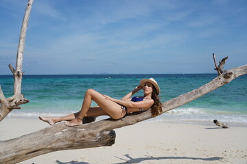 woman with a hat and bikini on the beach in krabi thailand, poda island, model shooting