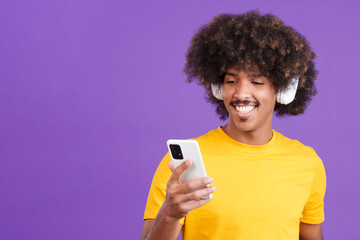 African man listening to music with headphones and a mobile