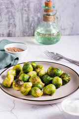 Roasted Brussels sprouts on a plate on the table. Vegetarian diet. Vertcal view