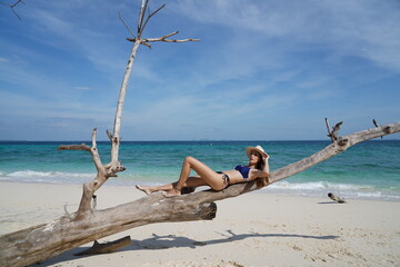 woman with a hat and bikini on the beach in krabi thailand, poda island, model shooting