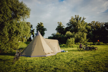 Fahrräder an einem Tipi-Zelt auf einem Campingplatz  im Licht der Abendsonne