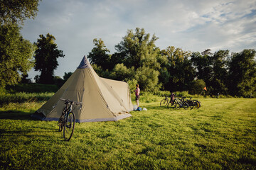 Fahrräder an einem Tipi-Zelt auf einem Campingplatz  im Licht der Abendsonne
