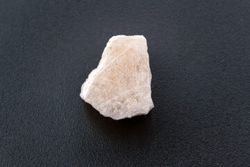 An unworked fragment of red gypsum, black background