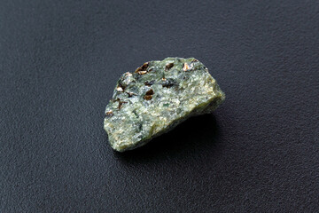 Rock with peridot olivine mineral, black background. Close-up