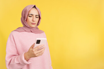 Worried muslim woman using a mobile phone