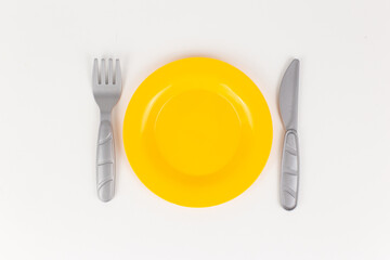 a plastic plate with a knife and fork on a white background