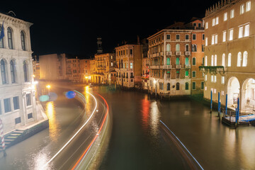 Venice, Italy Grand Canal night view of traditional low-rise buildings and wooden wharf pilings, seen from Rialto Bridge.