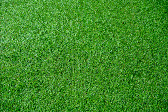 Green artificial grass natural background texture soccer field.