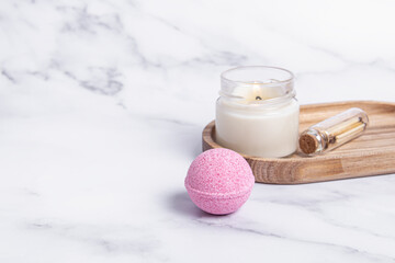 Obraz na płótnie Canvas Pink bath bomb, candle and wooden matches on marble background. Space for text. Home spa