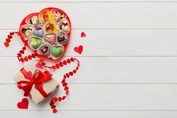 Valentine day composition: sweet candy, with gift boxes with bow and red felt hearts, photo template, background. Top View with copy space